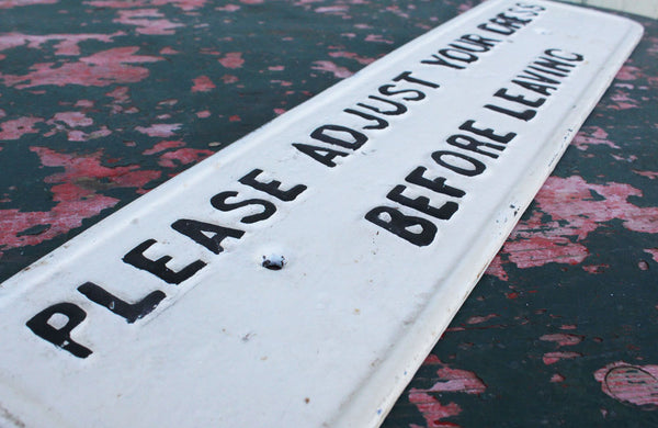 A Cast Iron Victorian Sign "Please Adjust Your Dress" Before Leaving"